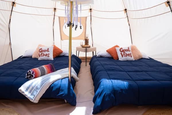 Two queen beds inside a glamping yurt